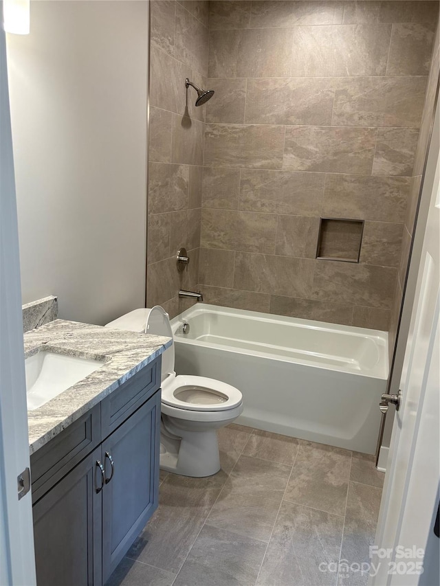 full bathroom featuring toilet, vanity, and tiled shower / bath combo