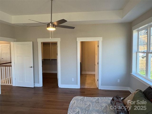 bedroom with a walk in closet, ceiling fan, a closet, and multiple windows