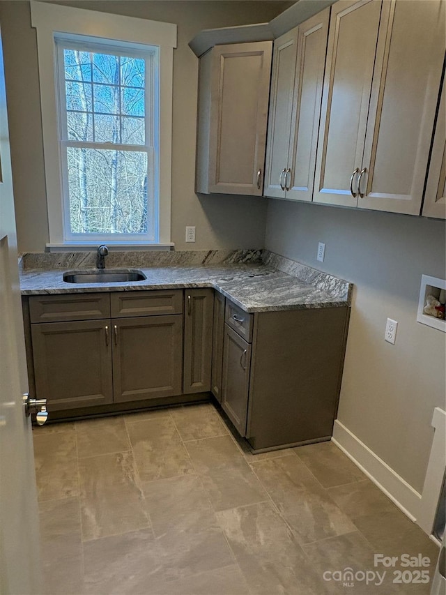 kitchen featuring light stone countertops and sink