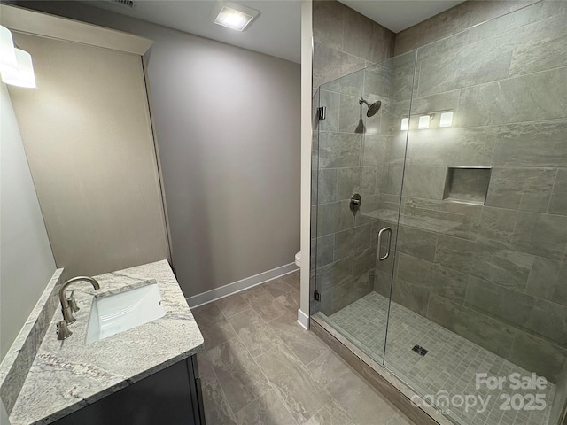 bathroom featuring toilet, a shower with door, and vanity