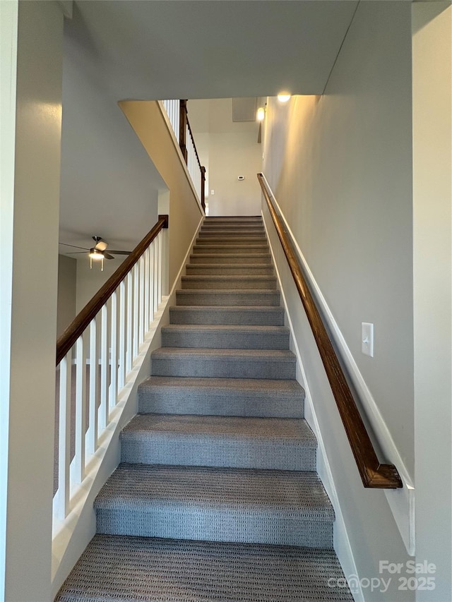 stairs featuring ceiling fan