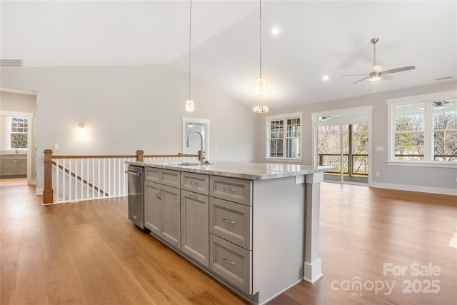 kitchen with a sink, light wood-type flooring, a ceiling fan, vaulted ceiling, and gray cabinets