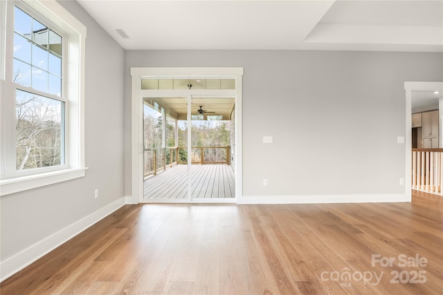 spare room featuring visible vents, a wealth of natural light, and baseboards