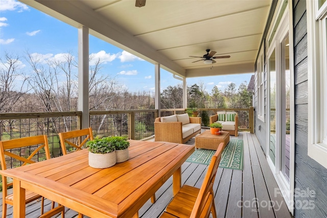 wooden deck featuring outdoor dining space, a ceiling fan, and an outdoor hangout area