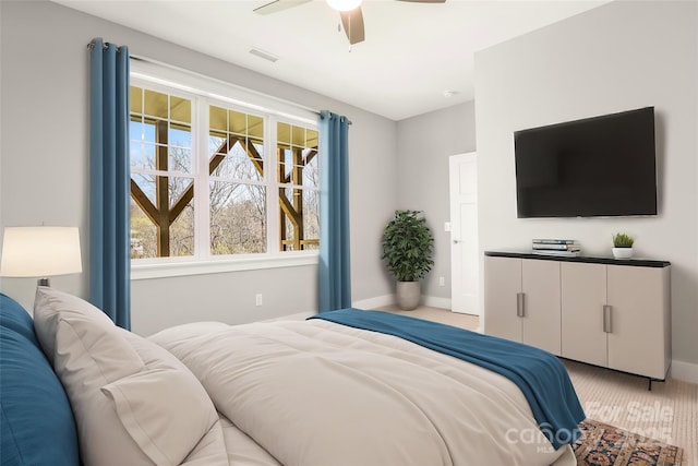 carpeted bedroom with visible vents, baseboards, and a ceiling fan