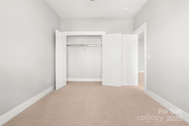 unfurnished bedroom featuring a closet, baseboards, and carpet floors