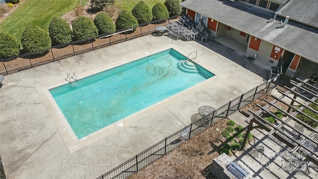 community pool with a patio and fence