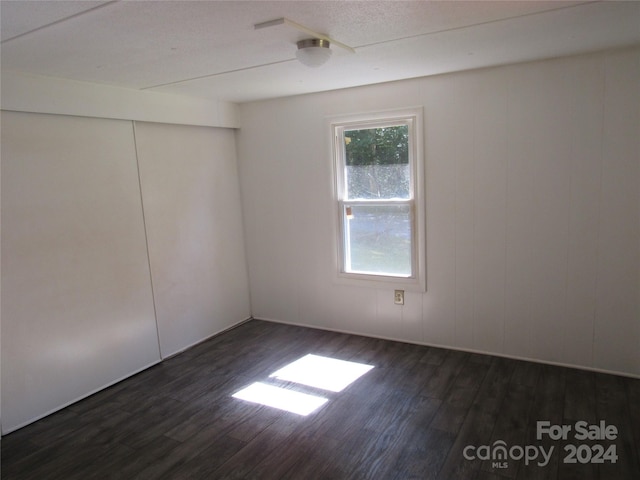 spare room with dark wood-type flooring