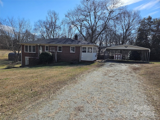 ranch-style home featuring a front lawn and a carport