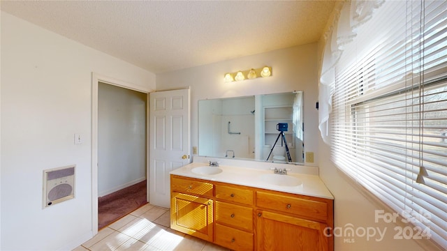 bathroom with a healthy amount of sunlight, tile floors, dual sinks, and large vanity