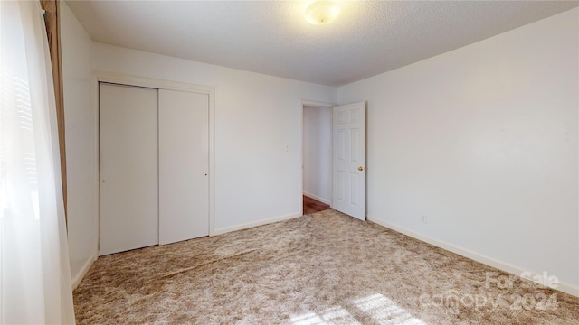 unfurnished bedroom with a closet and light carpet