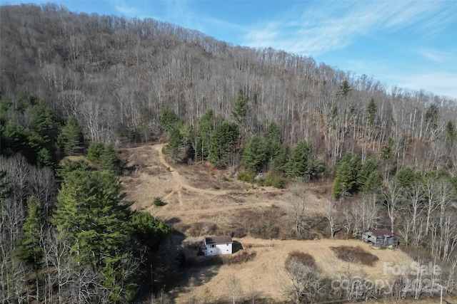 birds eye view of property featuring a view of trees