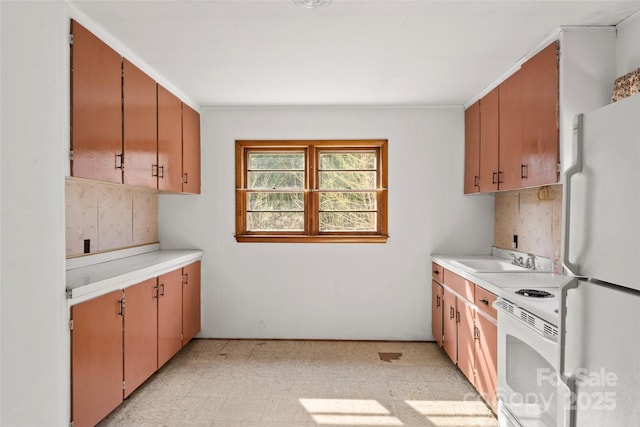 kitchen featuring a sink, white appliances, light floors, light countertops, and decorative backsplash