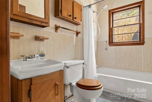 bathroom with vanity, toilet, a wainscoted wall, and shower / bath combination with curtain