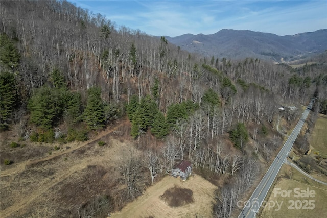 drone / aerial view featuring a mountain view and a view of trees