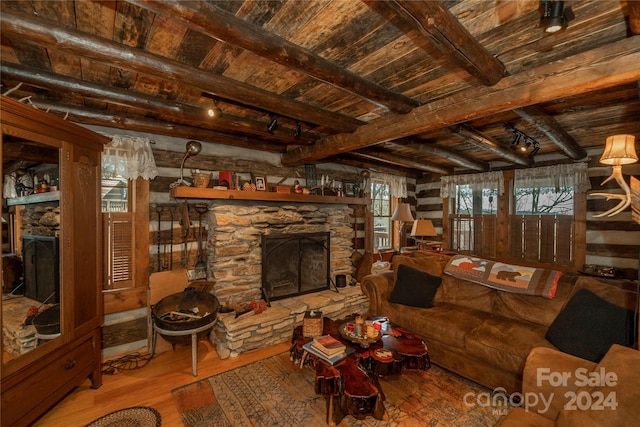 living room with wooden ceiling, a stone fireplace, hardwood / wood-style flooring, and beamed ceiling