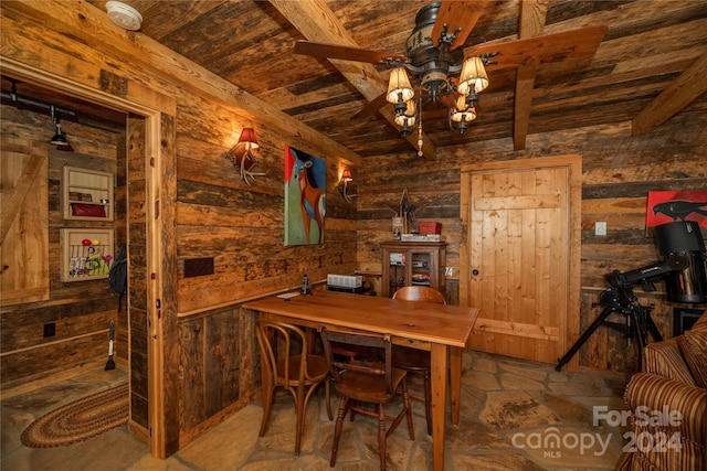 dining space with wood ceiling, dark tile floors, ceiling fan, and beamed ceiling