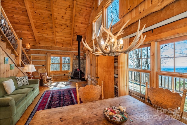 interior space featuring dark hardwood / wood-style flooring, a notable chandelier, wood ceiling, and a wood stove