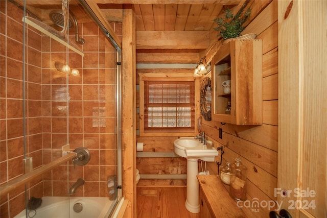 bathroom with shower / bath combination with glass door, wood walls, wooden ceiling, and hardwood / wood-style floors