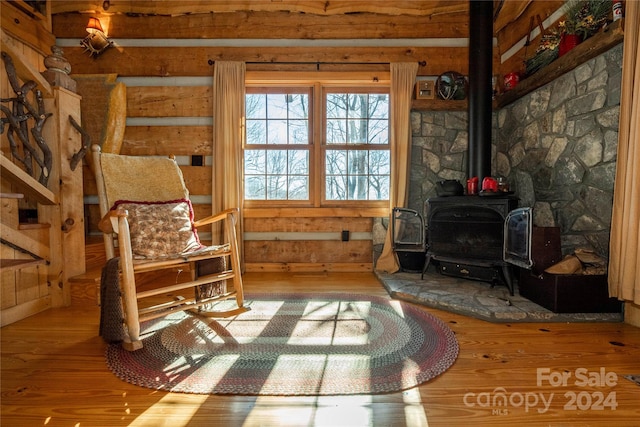 living area featuring light hardwood / wood-style floors and a wood stove