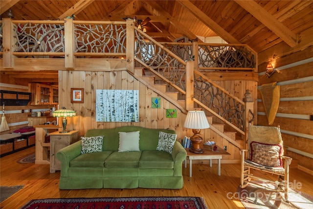 living room with wooden ceiling, wood walls, light hardwood / wood-style flooring, and lofted ceiling with beams