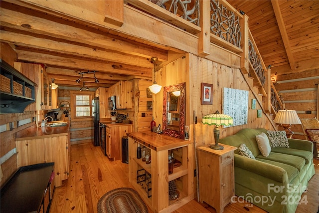 kitchen with wood walls, hanging light fixtures, and light hardwood / wood-style flooring