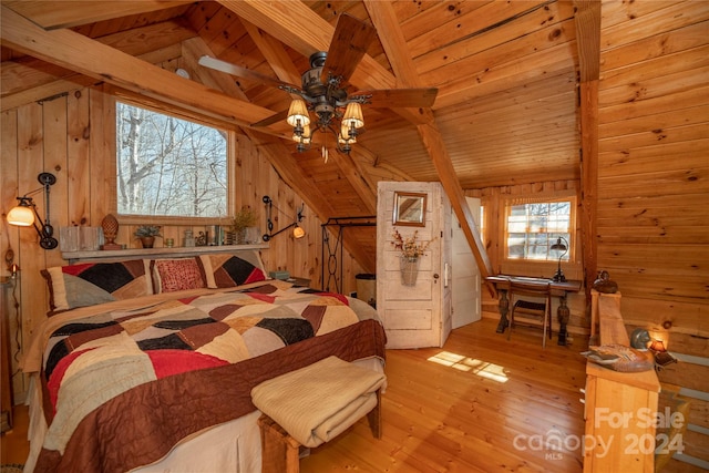 bedroom with ceiling fan, wood walls, light hardwood / wood-style floors, vaulted ceiling, and wooden ceiling