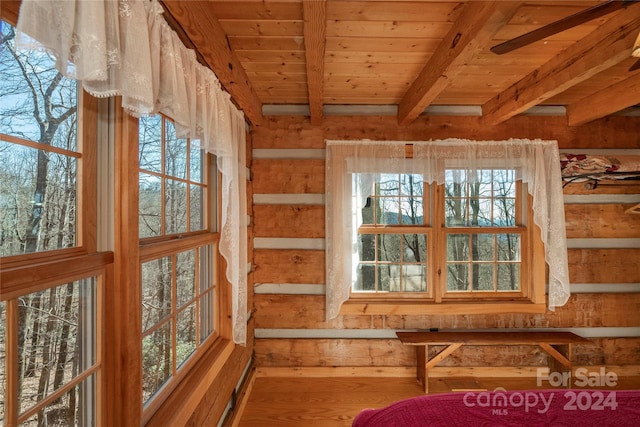 unfurnished bedroom with beam ceiling, multiple windows, wooden ceiling, and hardwood / wood-style flooring