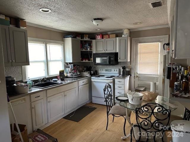 kitchen featuring sink, white electric range oven, tasteful backsplash, a textured ceiling, and light wood-type flooring