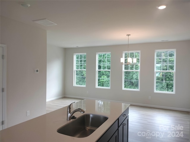 kitchen featuring a chandelier, pendant lighting, light hardwood / wood-style floors, and sink