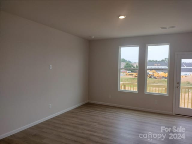 unfurnished room with hardwood / wood-style flooring