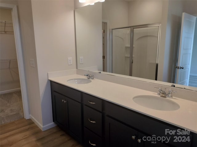 bathroom featuring wood-type flooring, vanity, and a shower with door