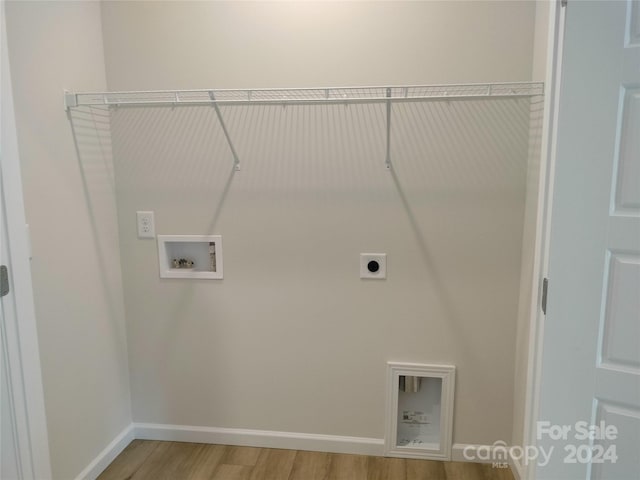 clothes washing area featuring hookup for an electric dryer, washer hookup, and hardwood / wood-style flooring