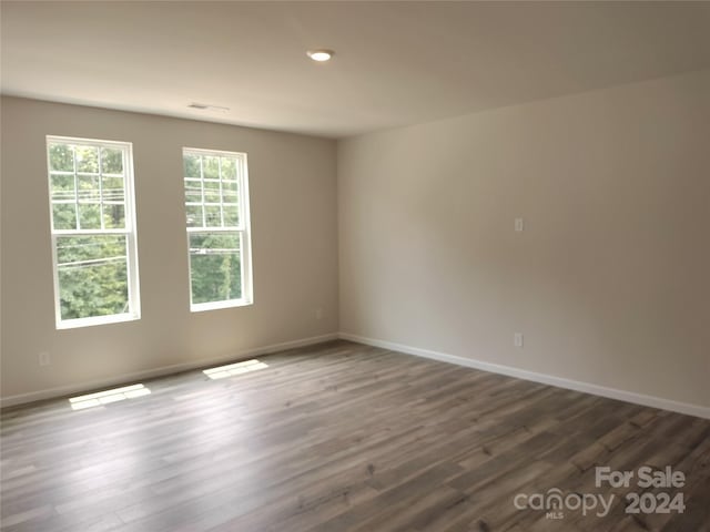 unfurnished room with dark wood-type flooring