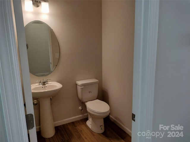 bathroom featuring hardwood / wood-style flooring, toilet, and sink