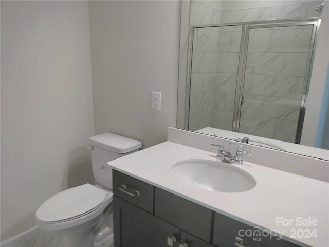 bathroom with an enclosed shower, vanity, and toilet