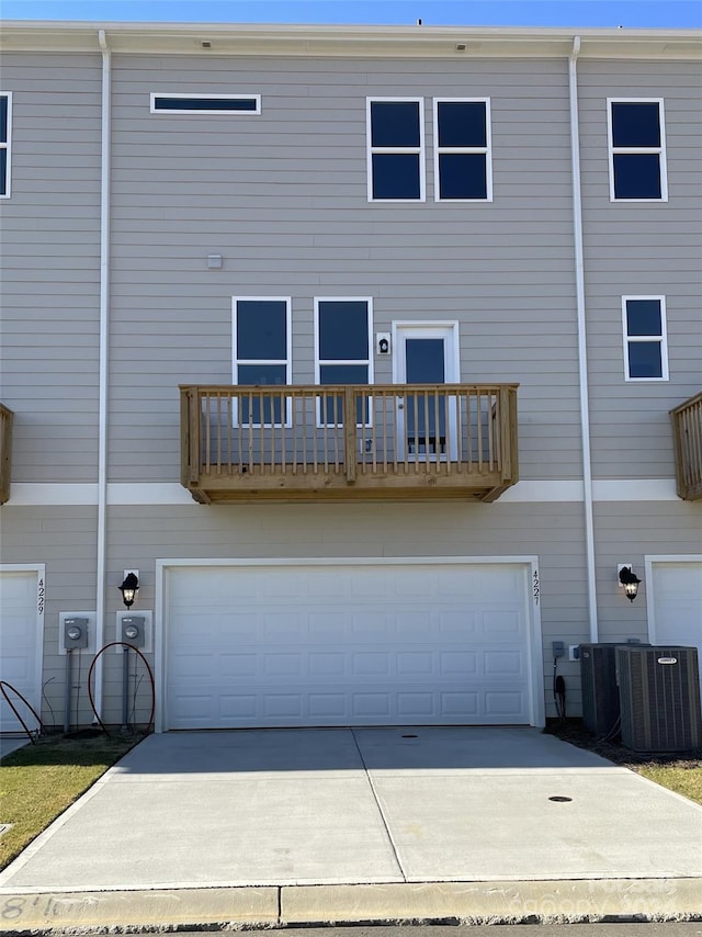 back of property featuring central air condition unit and a garage