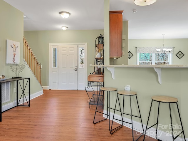 foyer with a notable chandelier and light hardwood / wood-style floors