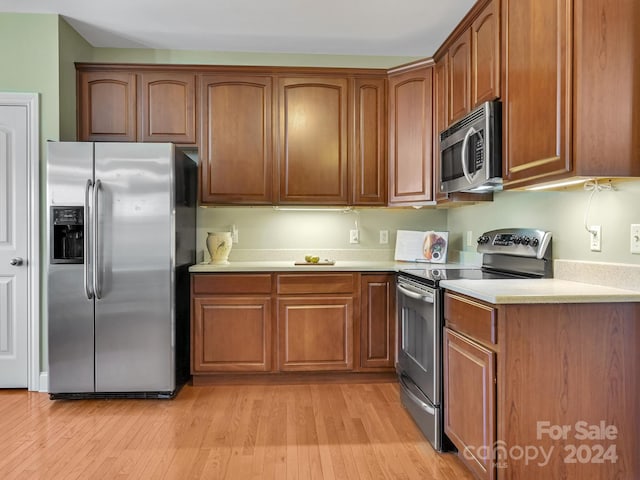 kitchen with light wood-type flooring and appliances with stainless steel finishes