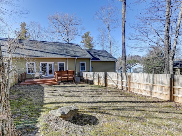 rear view of house featuring a deck and a yard