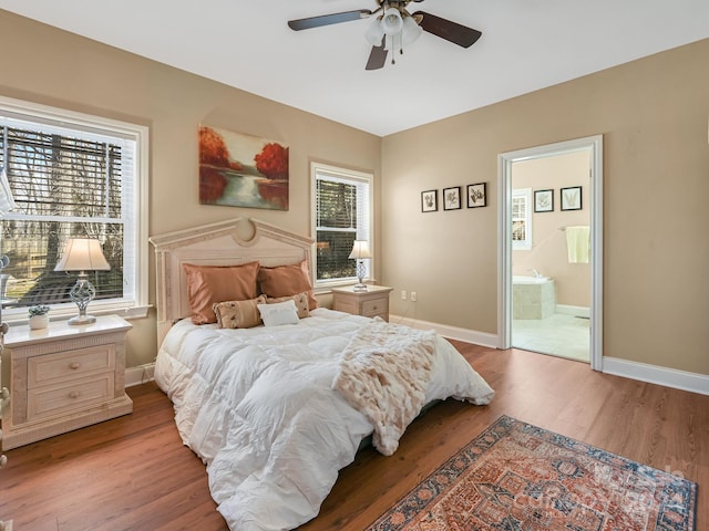 bedroom featuring ceiling fan, connected bathroom, wood-type flooring, and multiple windows