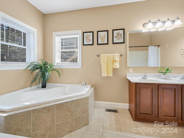 bathroom with tile patterned flooring, tiled bath, and vanity