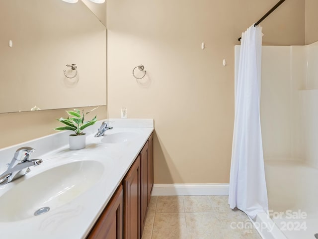 bathroom with dual bowl vanity and tile patterned flooring