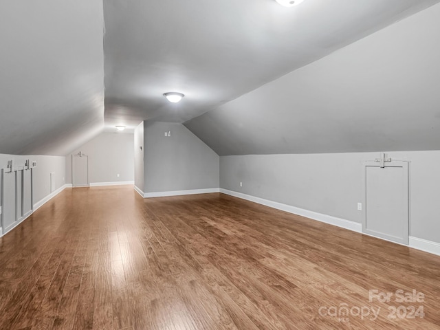 bonus room with lofted ceiling and hardwood / wood-style floors