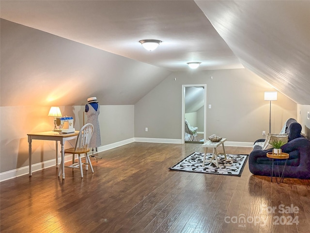 sitting room with dark wood-type flooring and vaulted ceiling