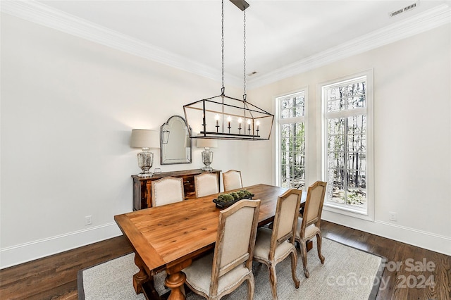 dining space with a chandelier, dark hardwood / wood-style floors, and crown molding