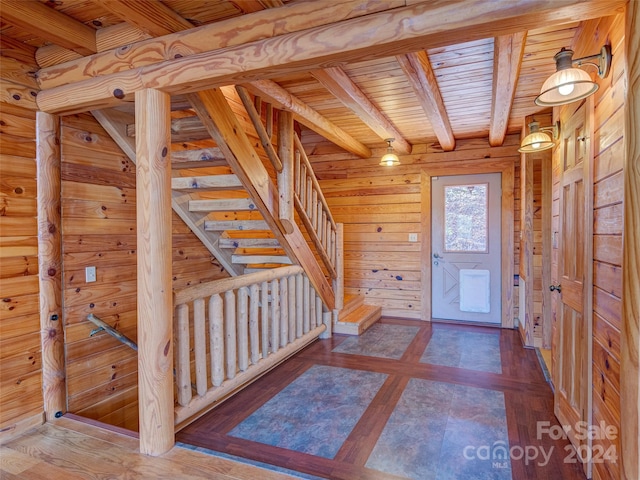 foyer featuring beam ceiling, wooden walls, and wood ceiling