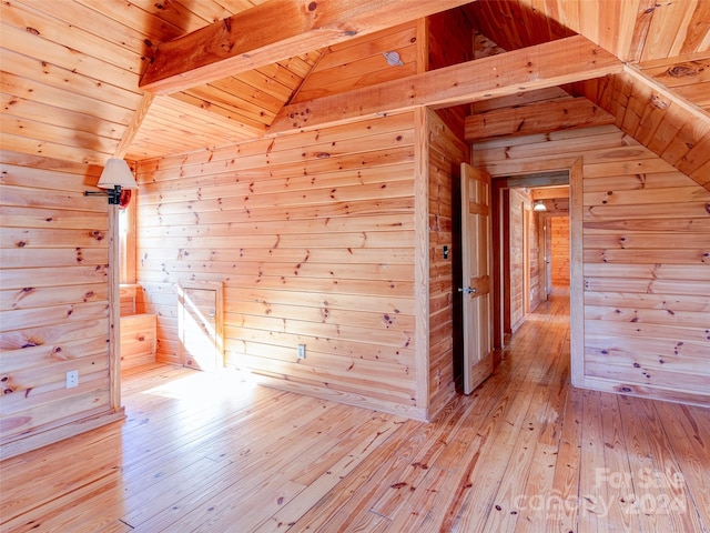 bonus room featuring wood ceiling, wood walls, lofted ceiling with beams, and light wood-type flooring