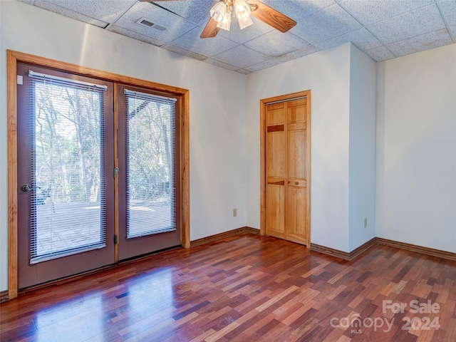 spare room featuring a paneled ceiling, hardwood / wood-style flooring, and ceiling fan