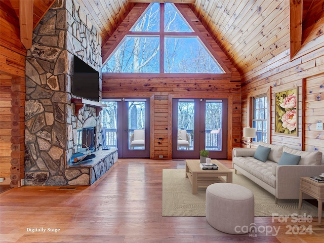 living room with a fireplace, french doors, high vaulted ceiling, and wood-type flooring